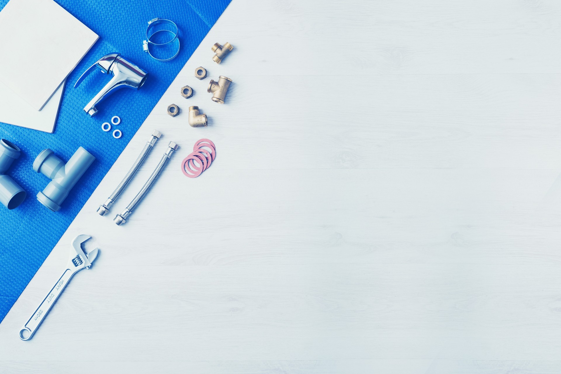 Plumber's work table banner with work tools, faucet, tiles and color swatches, top view, copy space at center